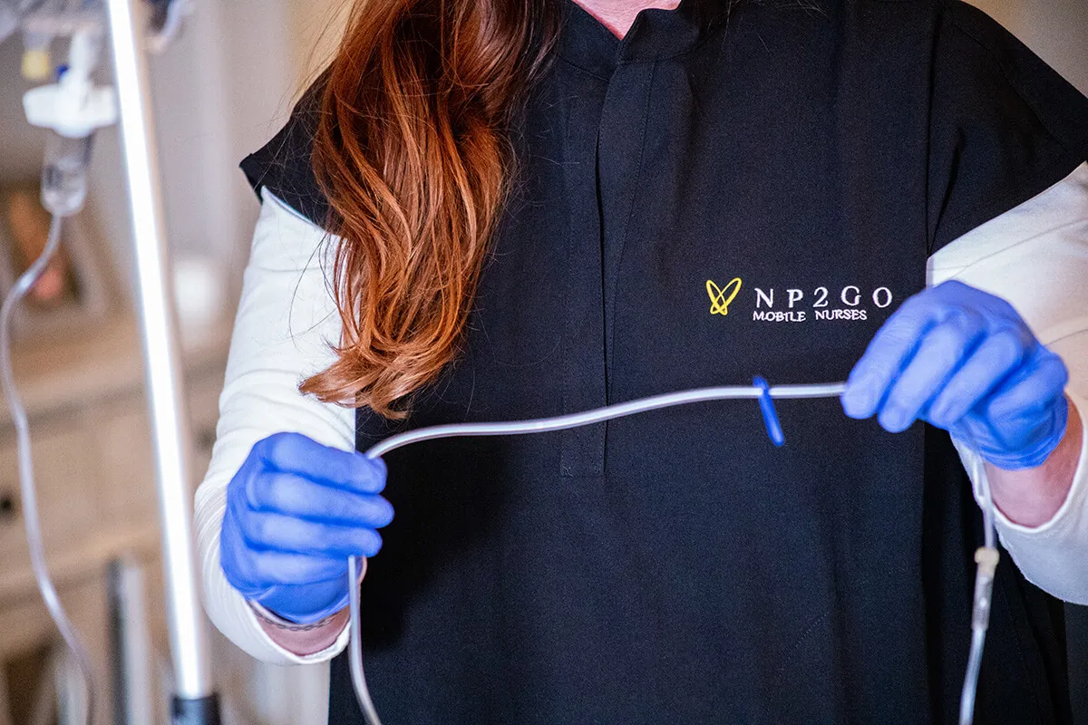 Can You Administer IV Fluids OKC at Home? - NP2GO NP2GO nurse preparing IV infusion