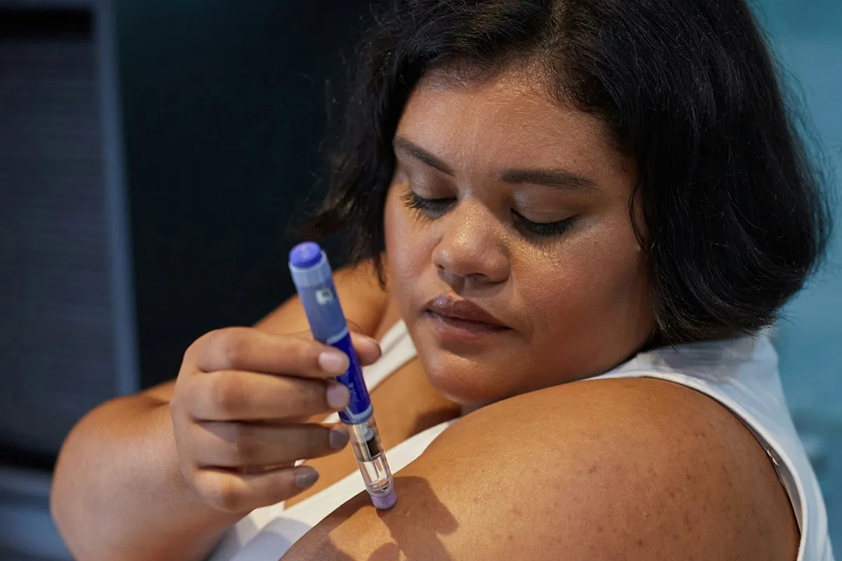 A woman giving herself a weight loss injection