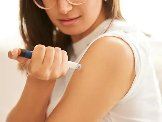 A woman injecting a weight loss Oklahoma shot in her arm